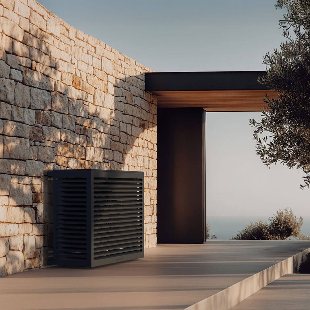 Cache clim gris anthracite Cabanaclim installé sur terrasse contemporaine avec mur en pierre et vue mer.