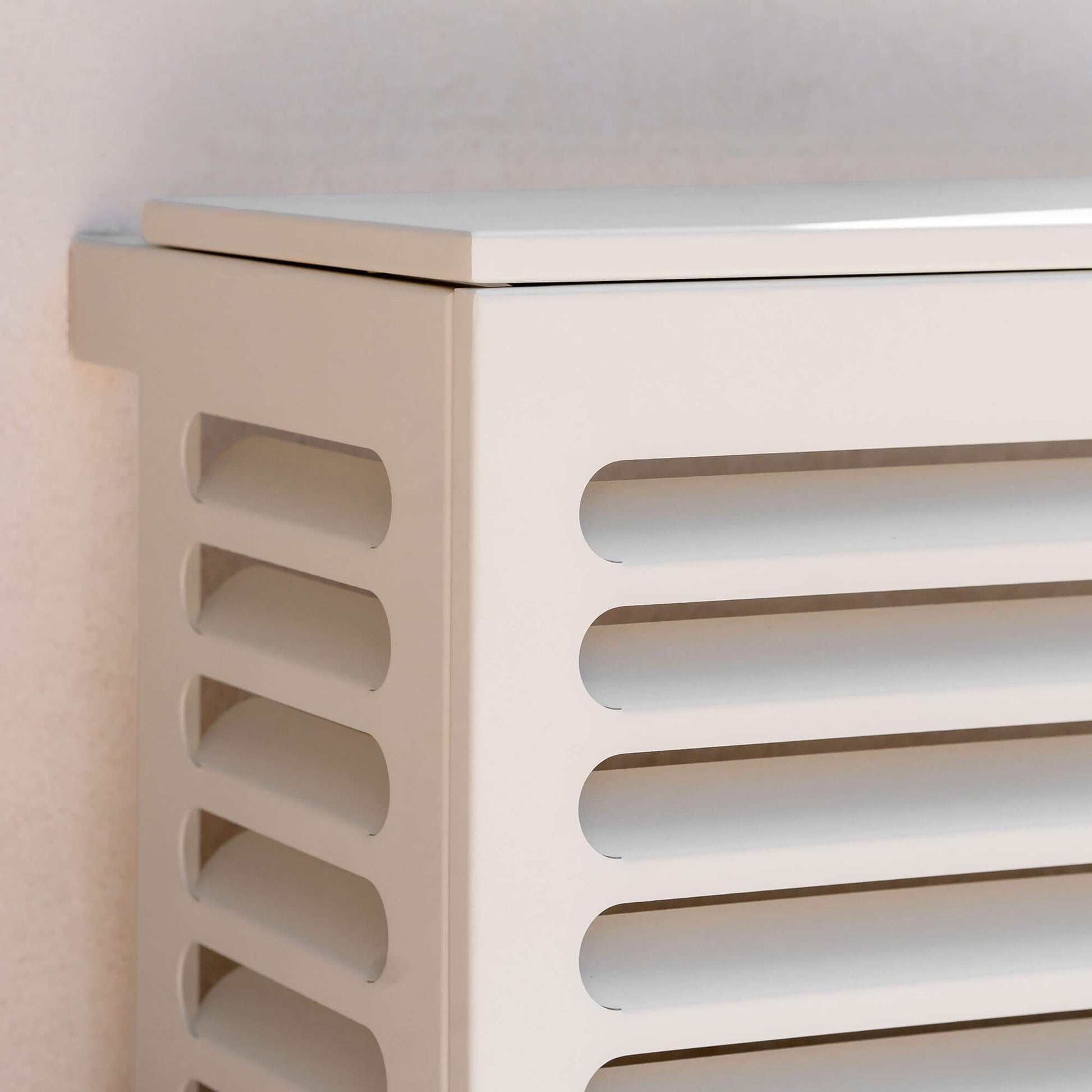 Cache clim blanc (RAL 9010) pour climatiseur ou pompe à chaleur – taille XS – vue 3/4 zoomé sur fond de mur clair, aluminium thermolaqué avec persiennes, protection esthétique et durable pour unité extérieure.